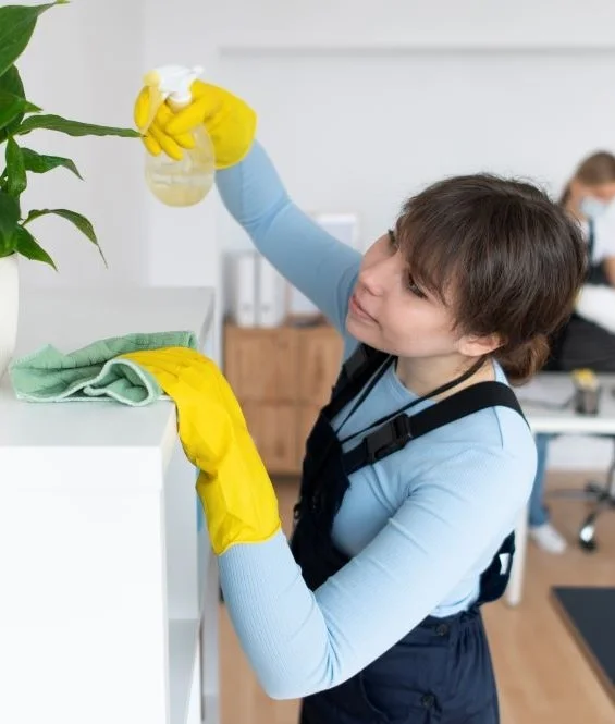 Een vrouw die een kamer schoonmaakt en een plant op de water geeft, wat een frisse sfeer creëert